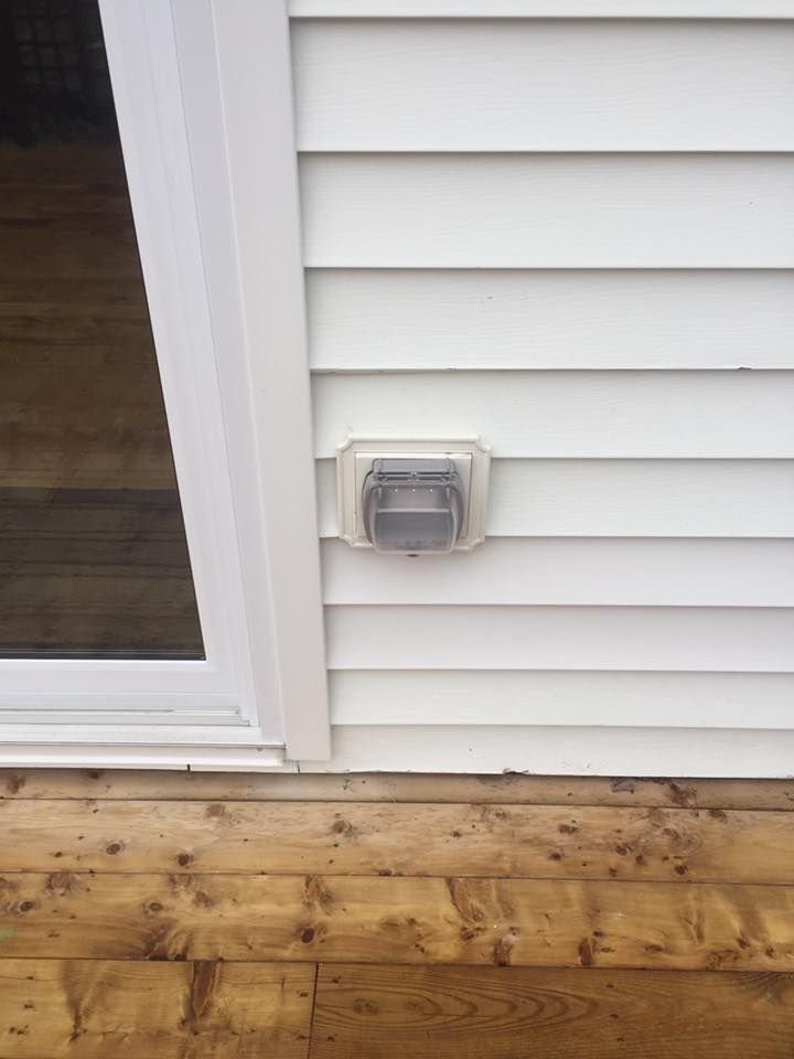 A white house with a sliding glass door and a light on the side of it.