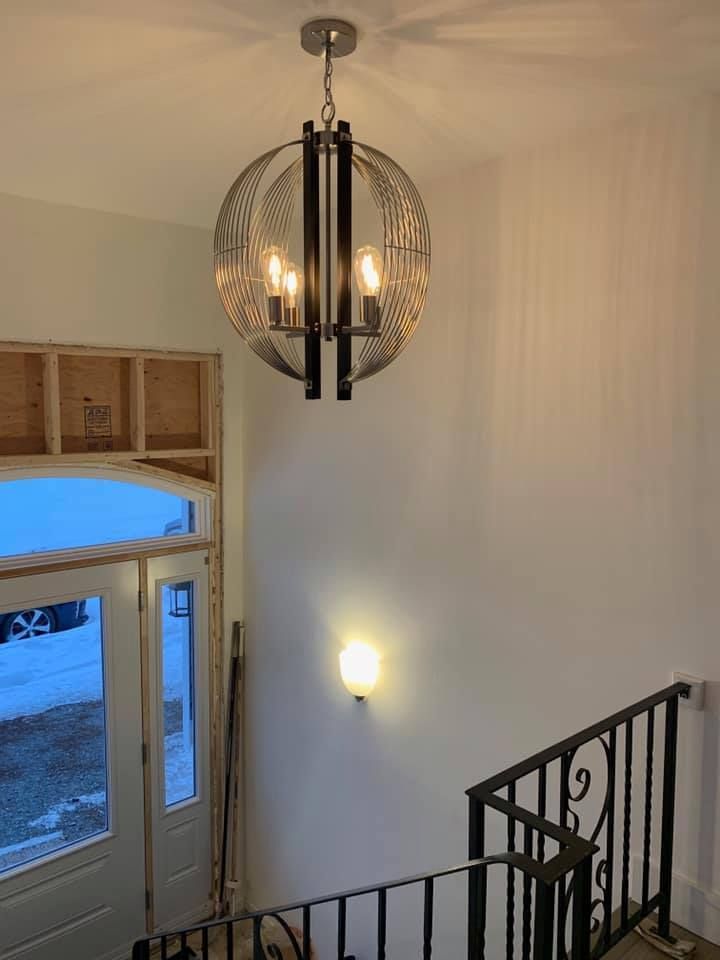 A chandelier is hanging from the ceiling above a staircase.