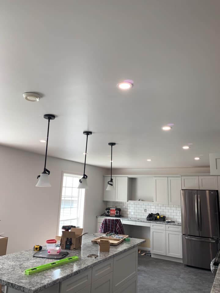A kitchen with white cabinets and a stainless steel refrigerator.