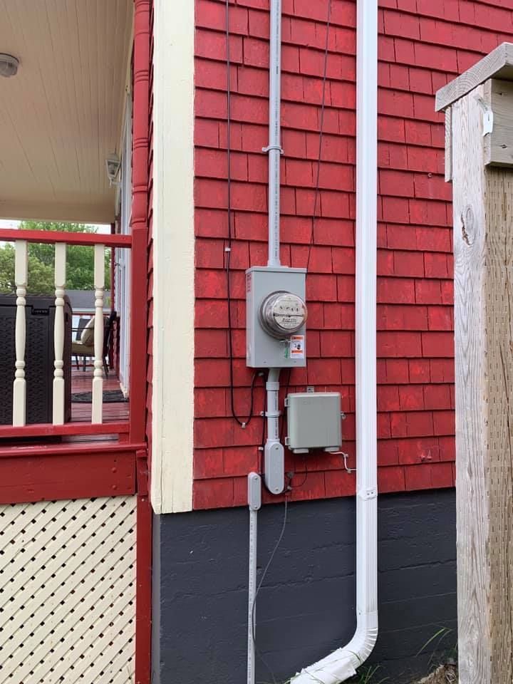 A red house with a meter on the side of it.