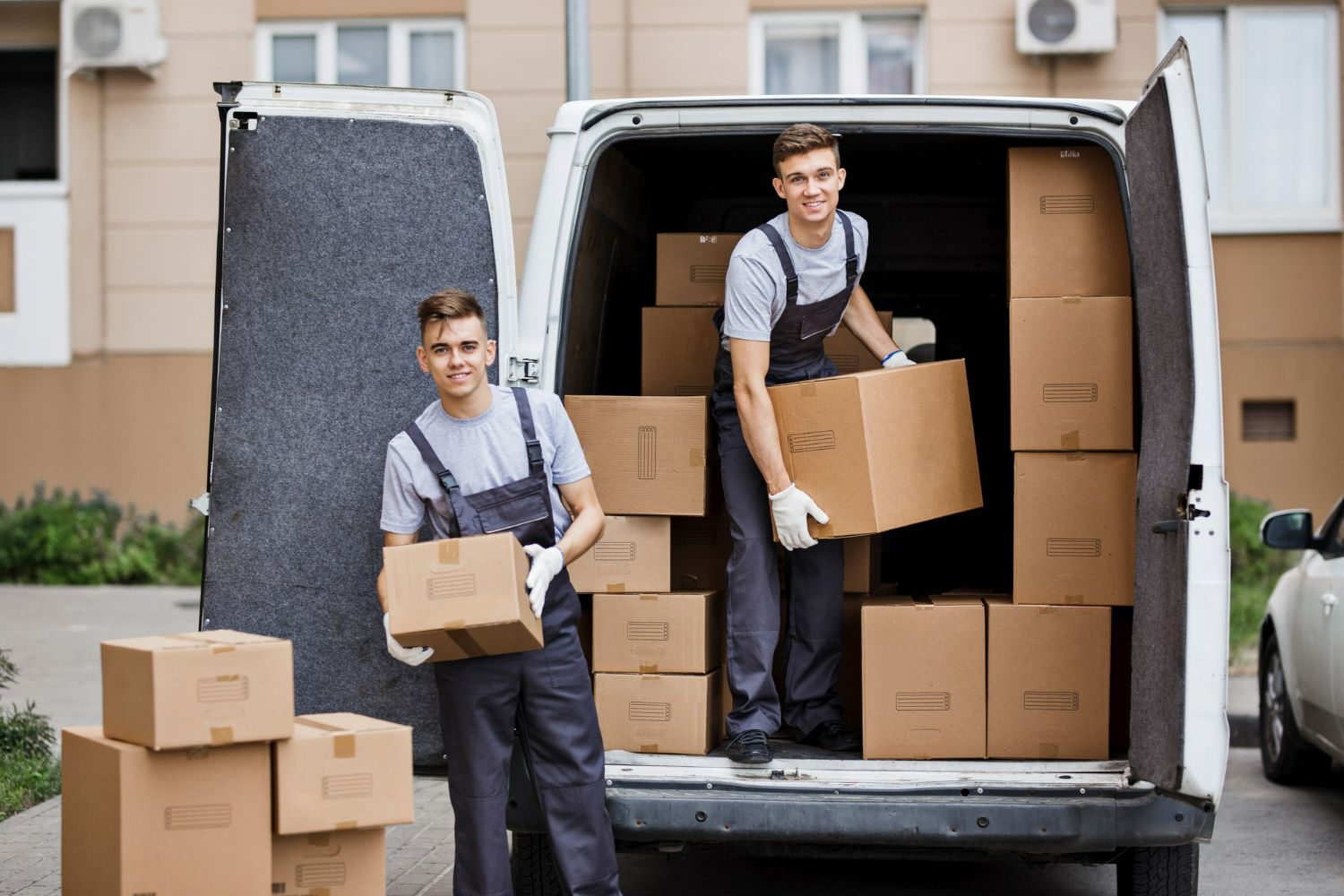 Two men are loading boxes into a van.