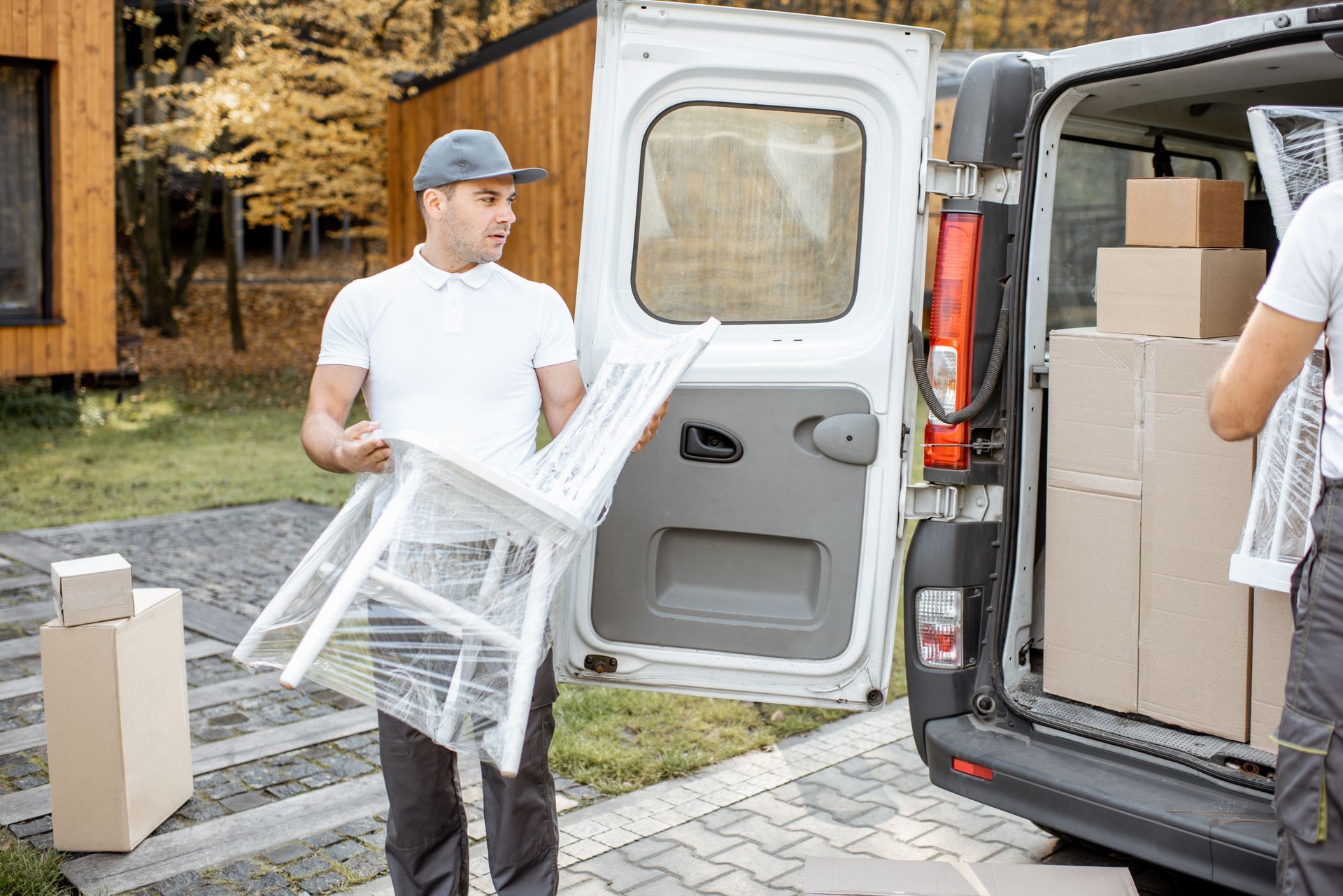 A man is carrying a chair into a van.