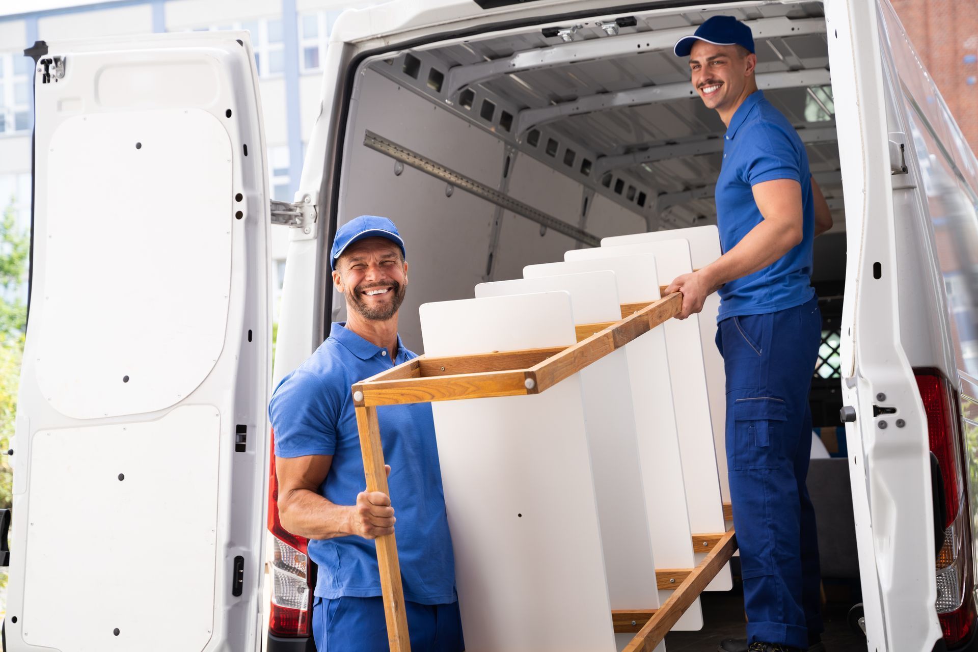 Two men are loading furniture into a van.