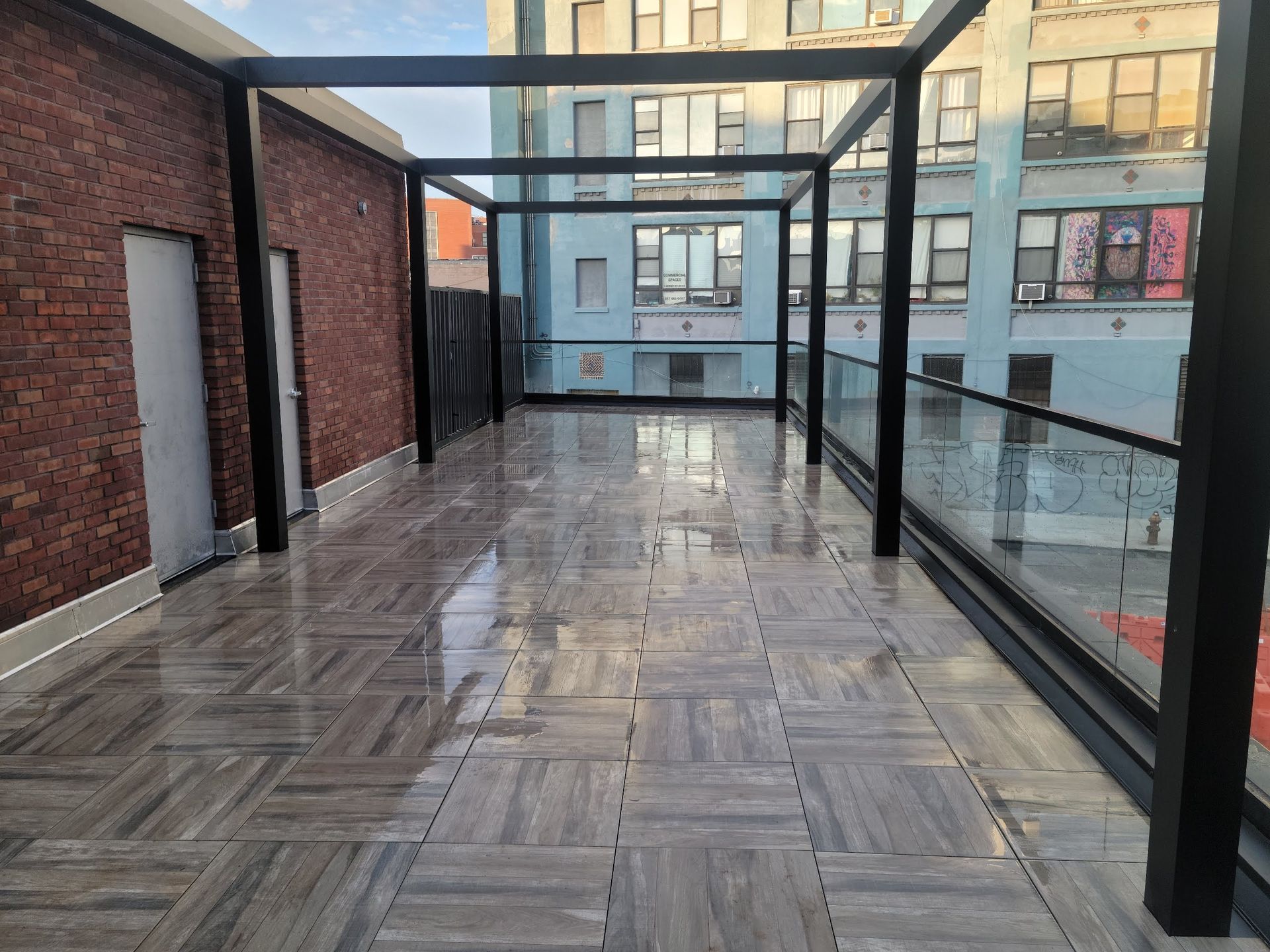 A corn field with a barn and silos in the background.