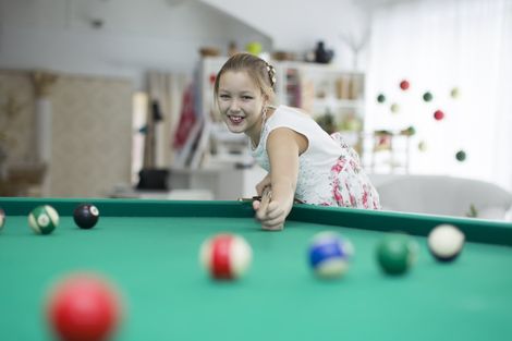girl playing pool at home