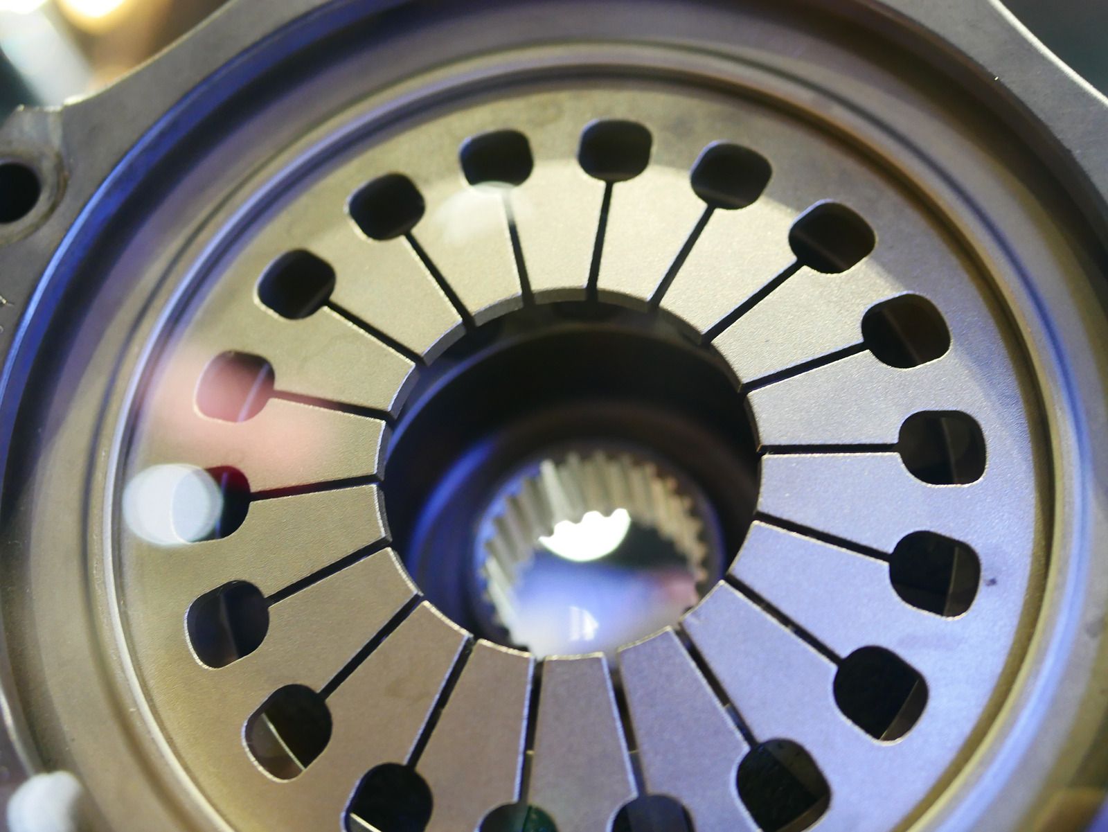 Close-up of a metallic clutch pressure plate with springs and circular ventilation slots