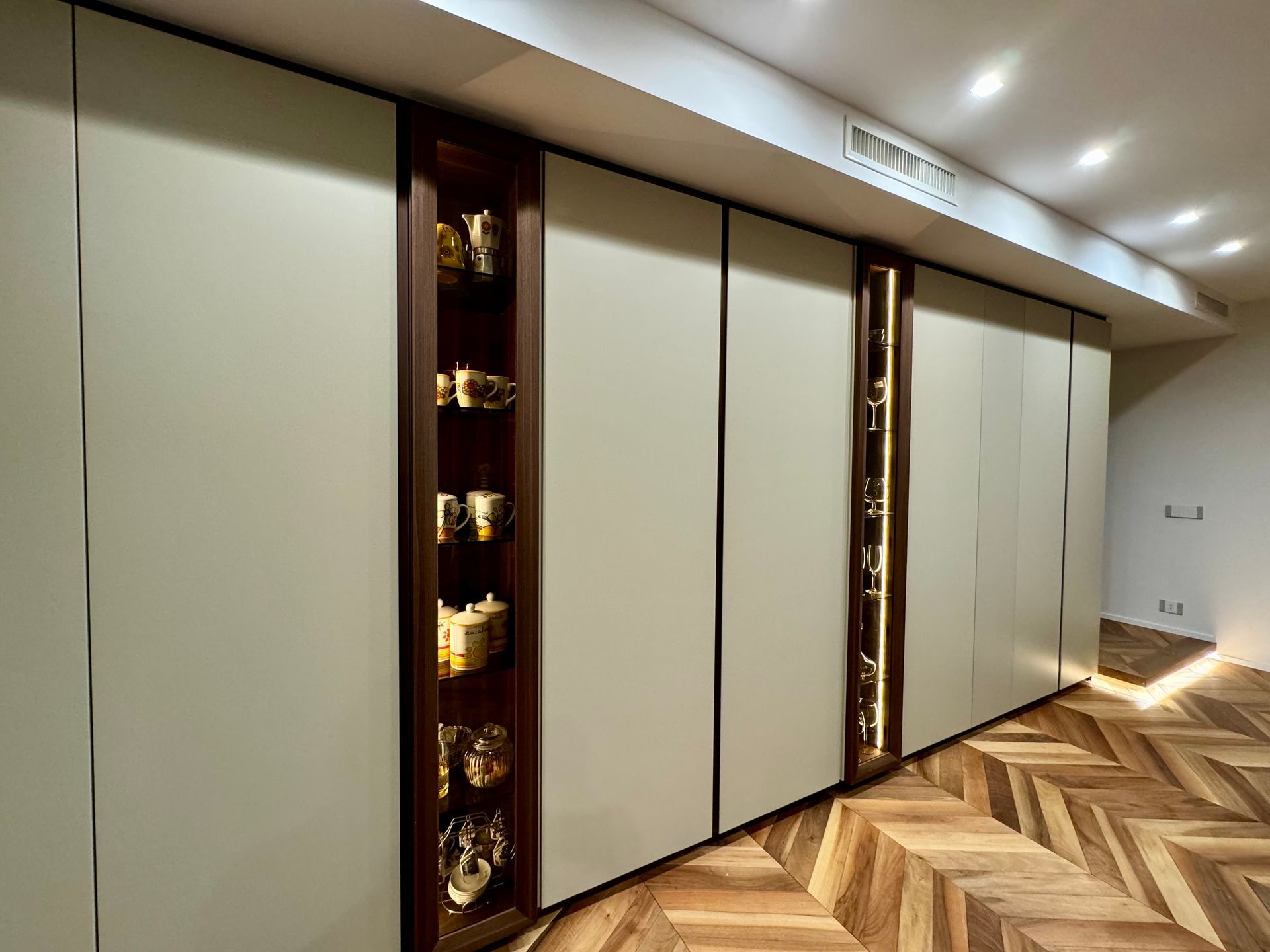 Un corridoio con pavimento in legno e pareti bianche