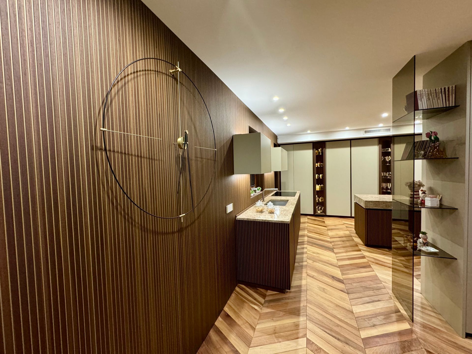 Una cucina con pavimento in legno e orologio a parete.