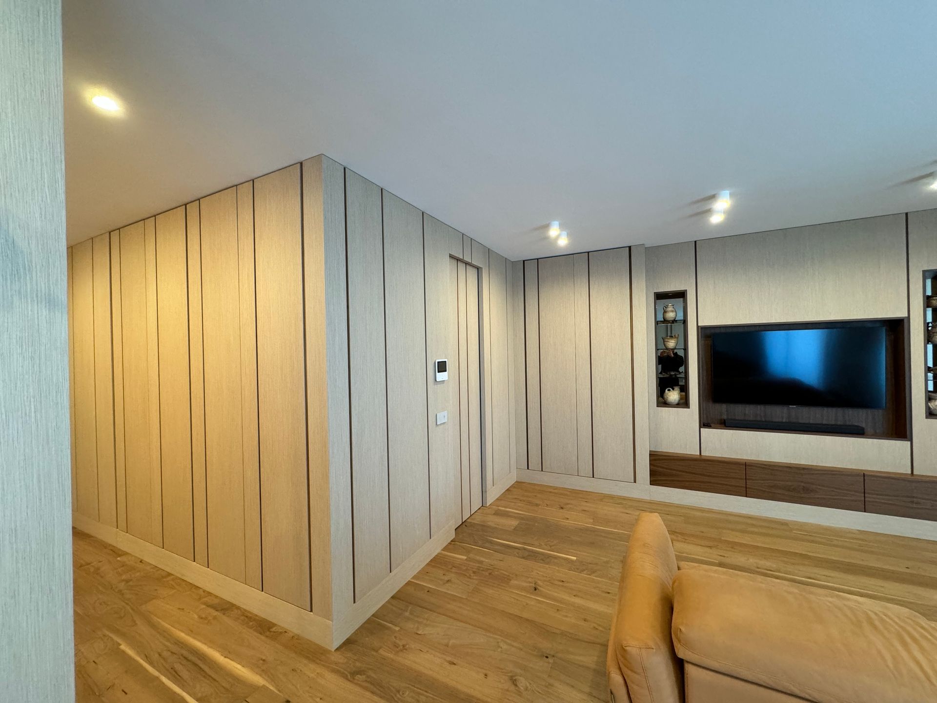 Un soggiorno con un divano e un televisore a parete.