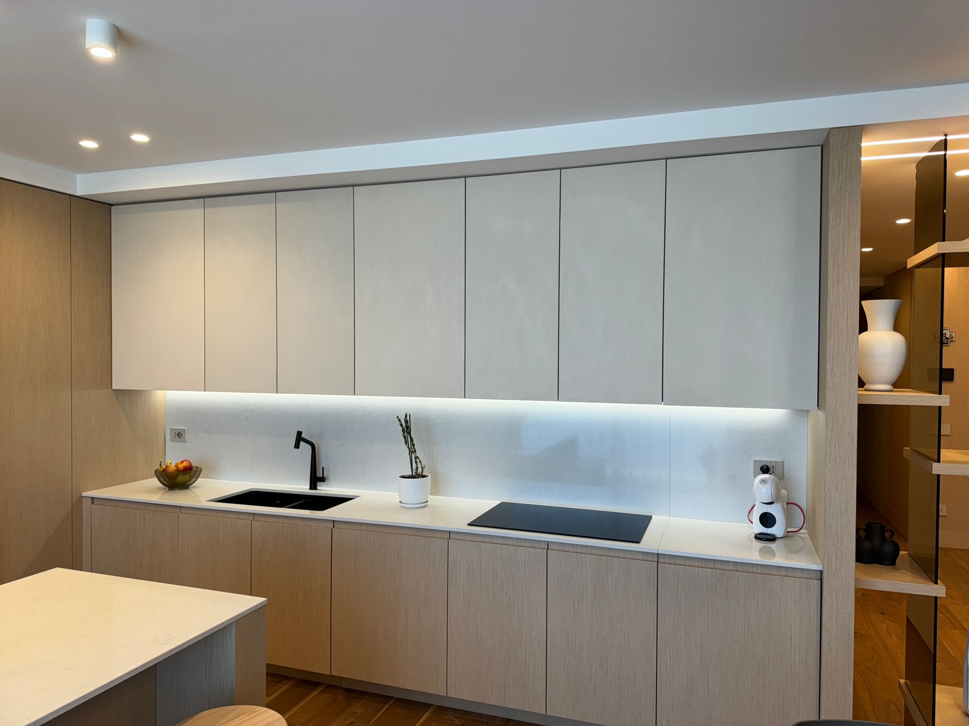 Una cucina con mobili bianchi, un lavello e un forno.