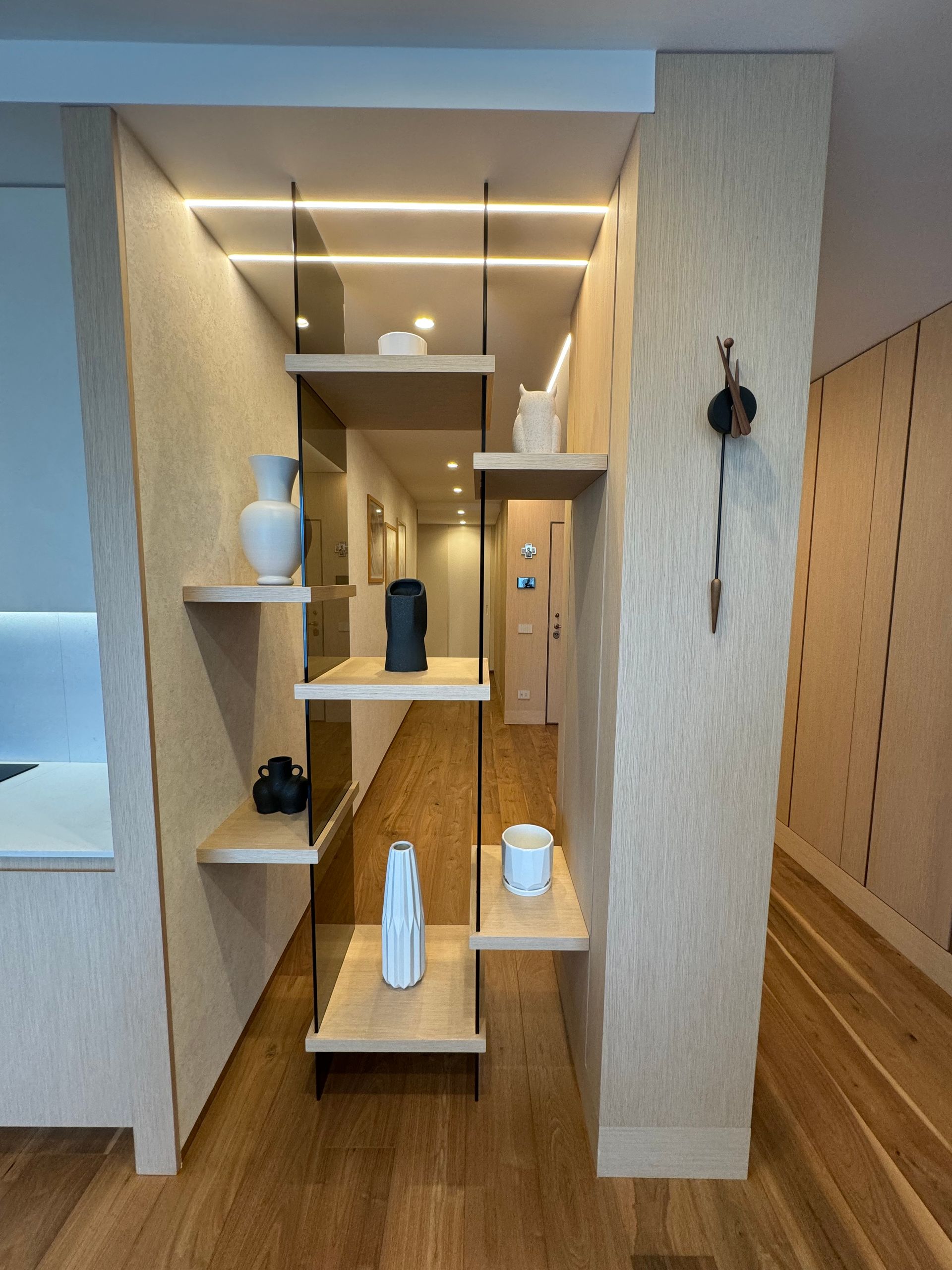 Un corridoio con sopra uno scaffale con dei vasi