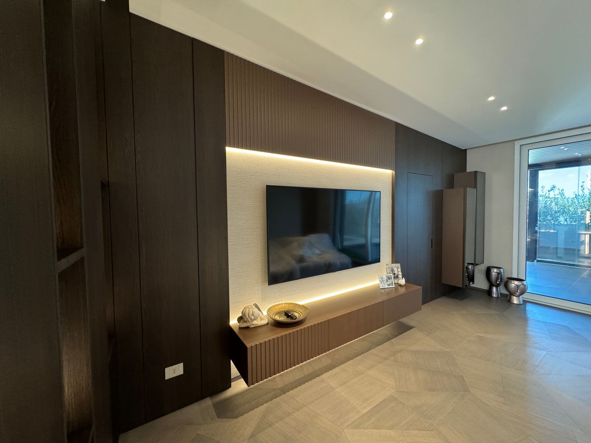 Un soggiorno con tv a schermo piatto fissata al muro.