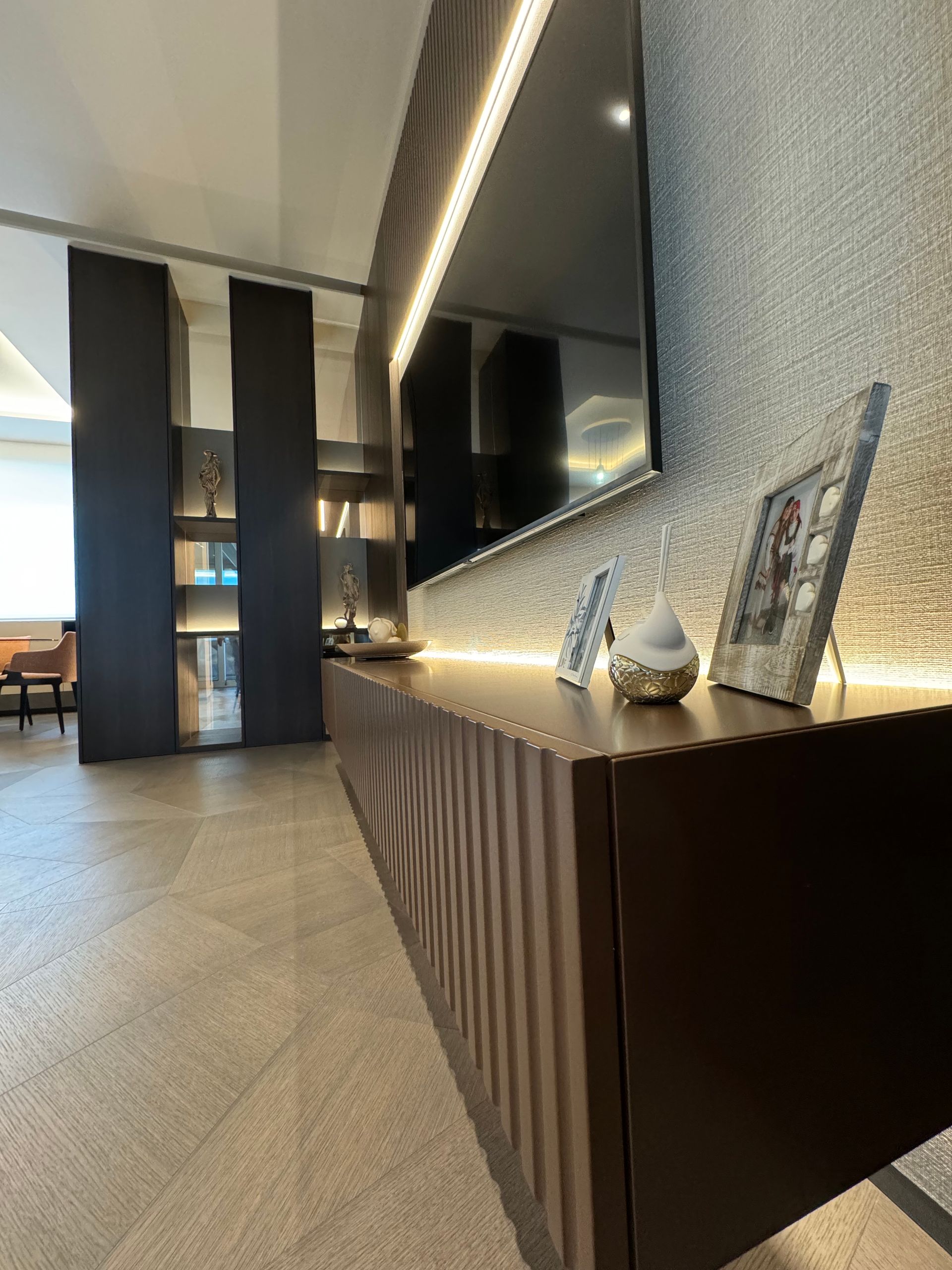 Un soggiorno con una grande tv a schermo piatto a parete.