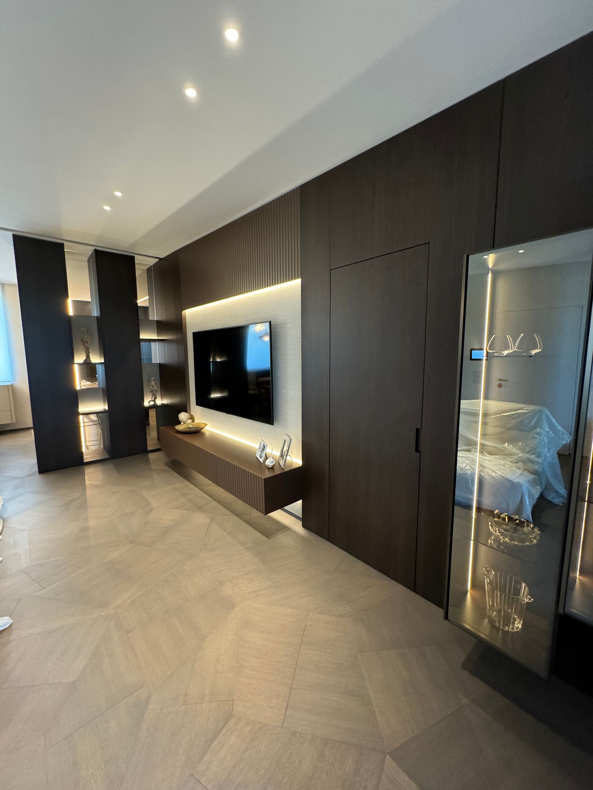 Un soggiorno con una grande tv a schermo piatto a parete.