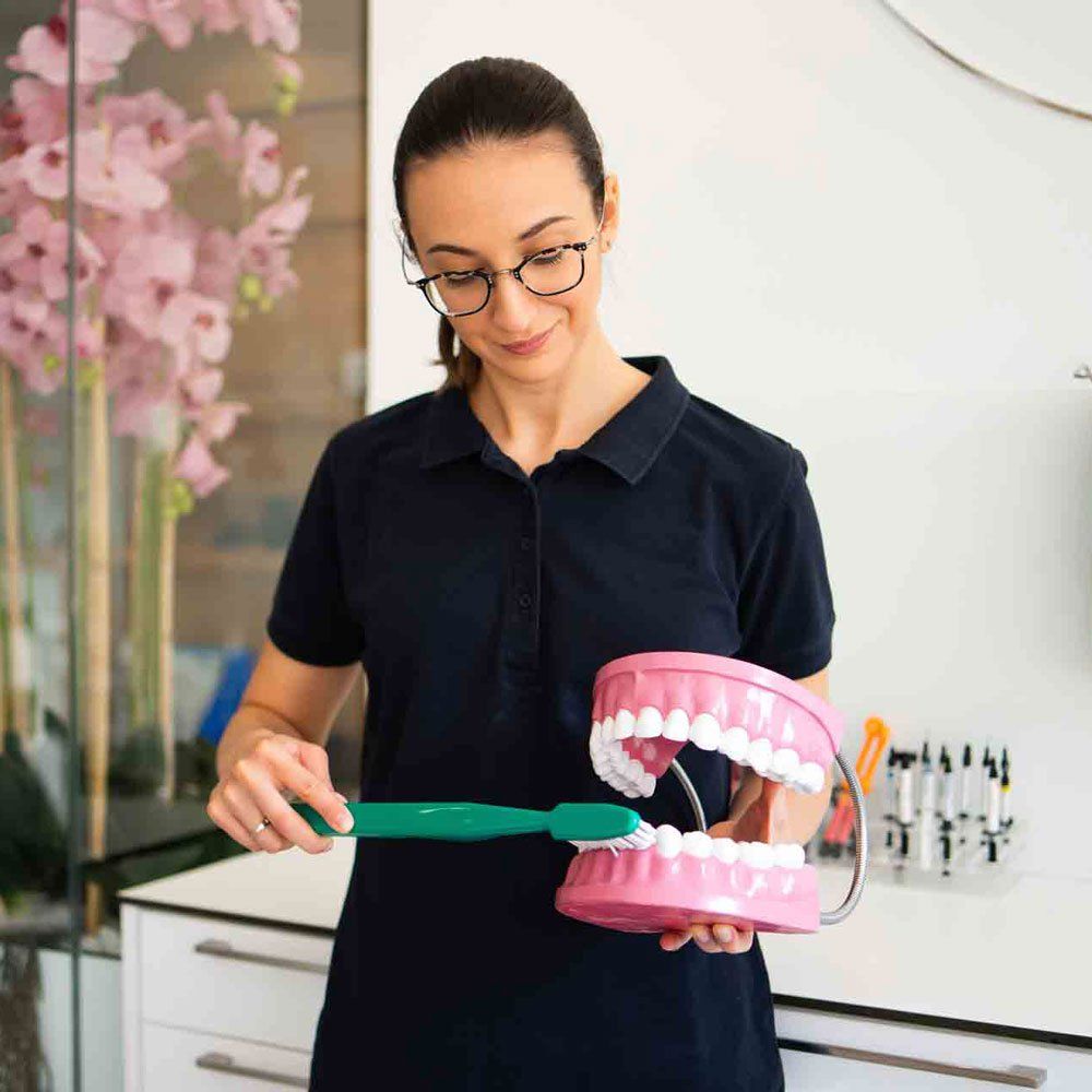 A Dentist Teaching how To Brush Teeth — Portage, IN — Airport Road Dental Associates, PC