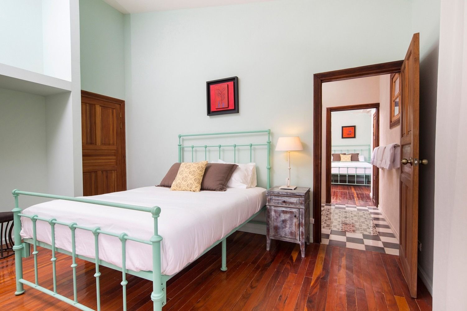 A bedroom with a large bed , chair , sliding glass doors and a ceiling fan.