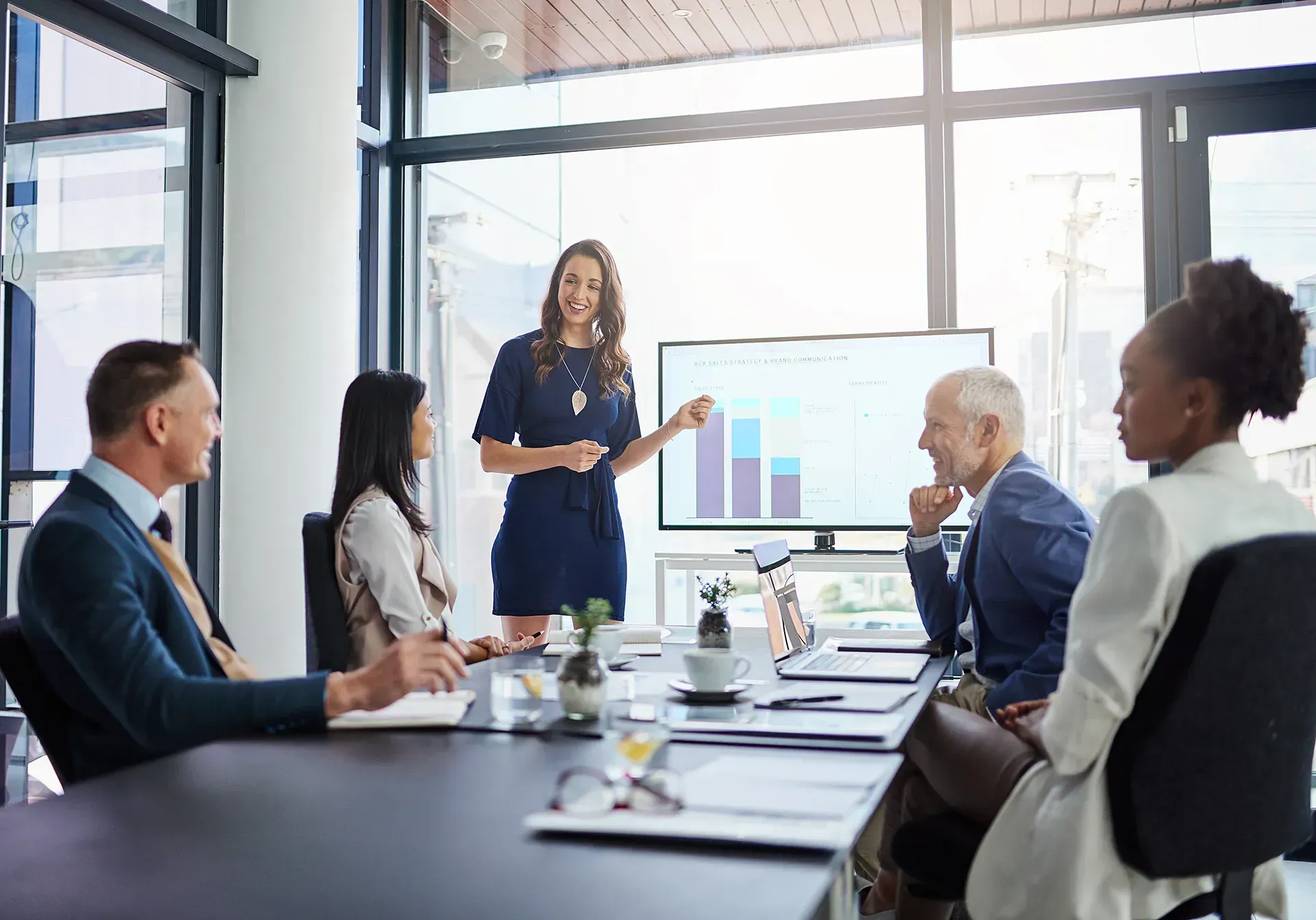 A woman is giving a presentation to a group of people in a conference room.