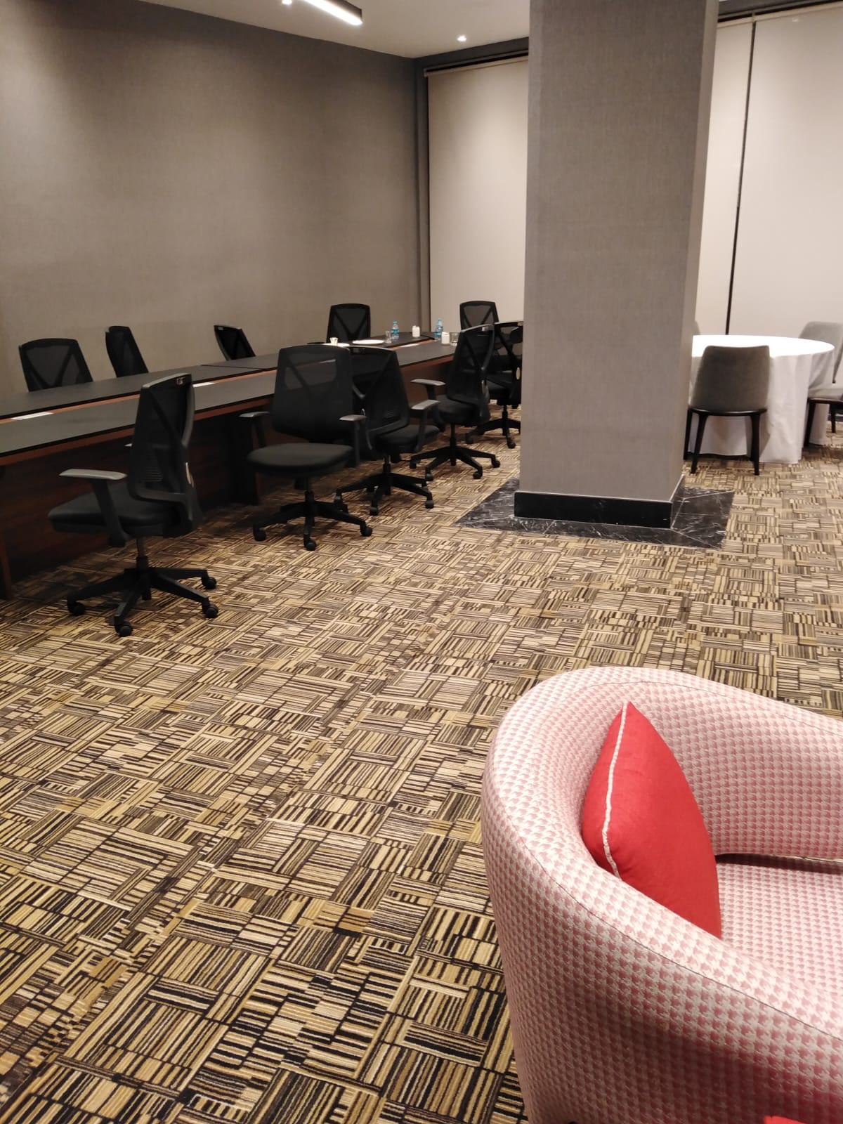 Ein Konferenzraum mit Tischen und Stühlen und einem roten Stuhl.