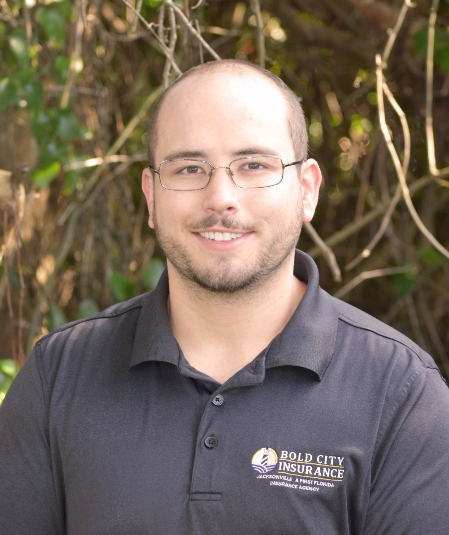 A man wearing glasses and a black shirt with the word insurance on it