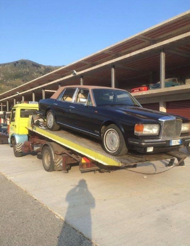Un'auto nera viene trainata da un carro attrezzi giallo