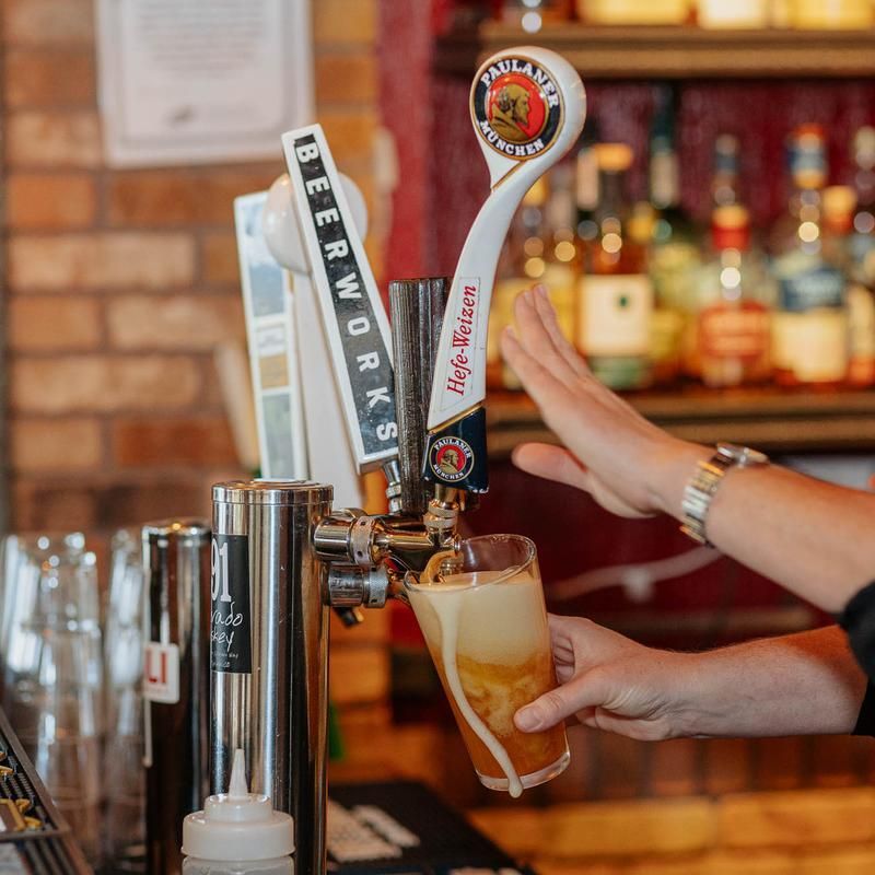 A person is pouring beer from a tap into a glass.
