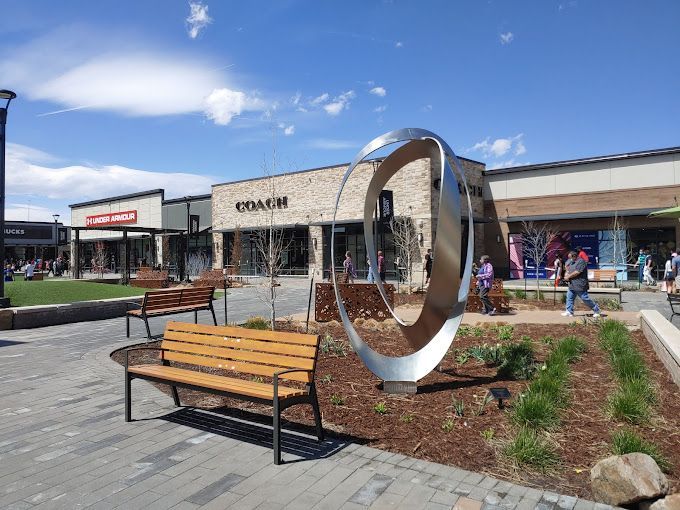 A wooden bench is sitting in front of a coach store.