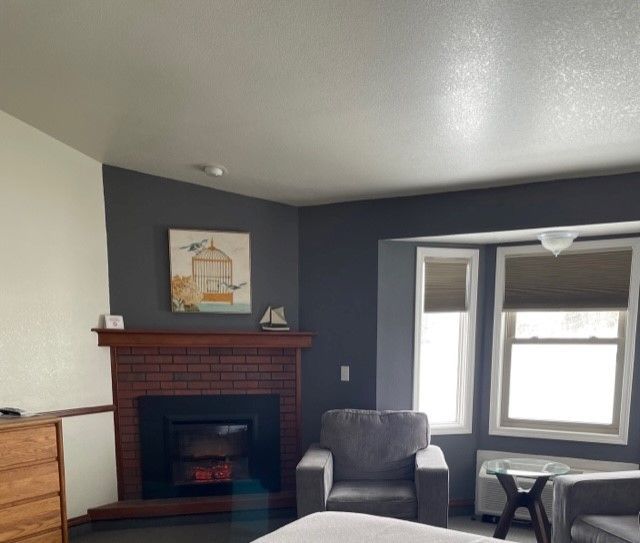 A living room with a fireplace and a painting on the wall