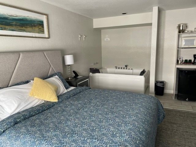 A hotel room with a bed and a jacuzzi tub