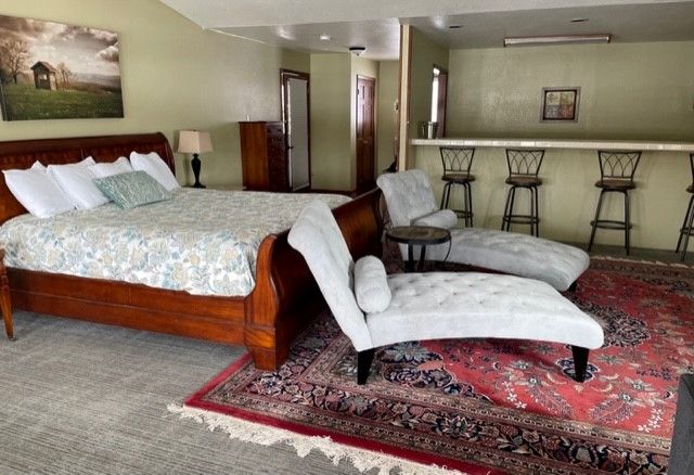 A bedroom with a bed , chairs and a rug