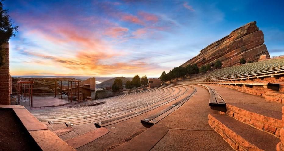 An empty amphitheater with a mountain in the background at sunset.