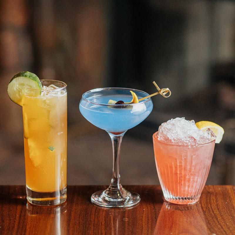 Three different types of drinks are sitting on a wooden table.
