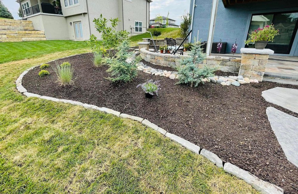 A backyard with a lush green lawn and a stone walkway.