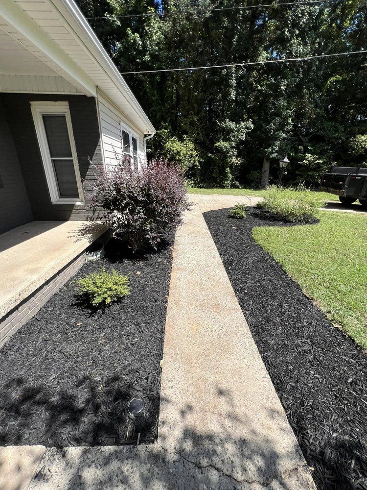 A walkway leading to a house with a truck parked in the driveway.