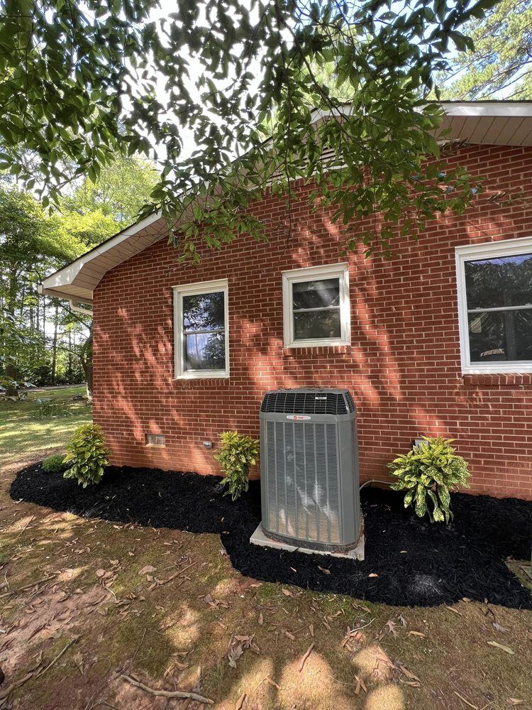 A brick house with a air conditioner on the side of it.