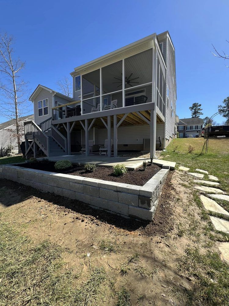 The back of a house with a screened in porch and a large deck.