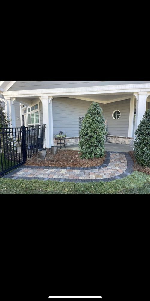 A house with a porch and a walkway in front of it.