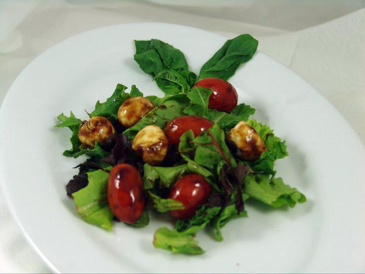 A salad with tomatoes and lettuce on a white plate.