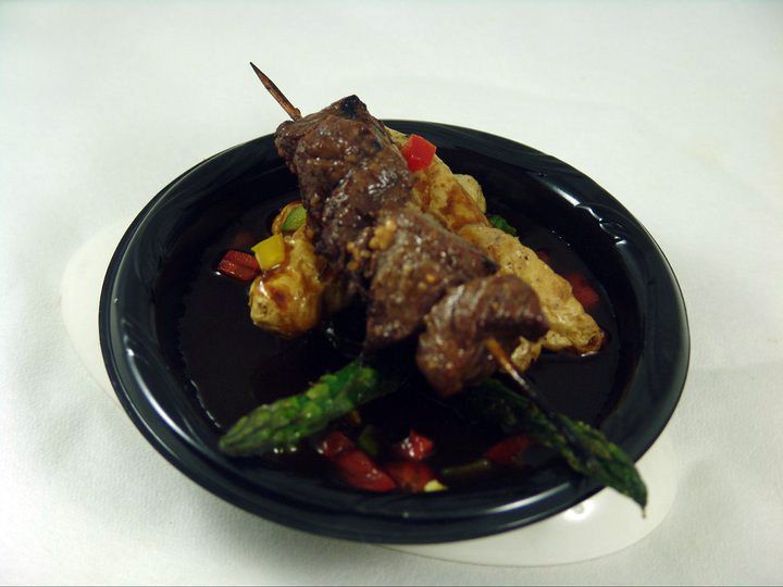 A plate of food with meat and vegetables on a table.