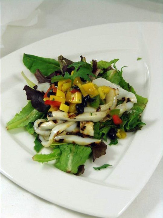 A close up of a salad on a white plate.