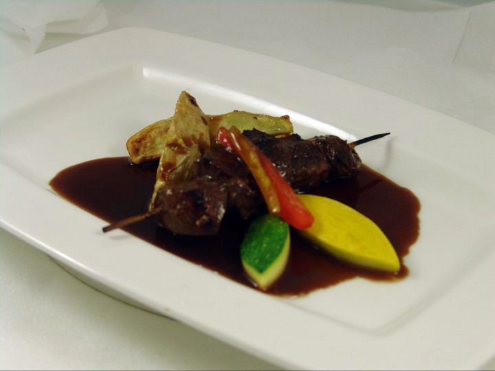 A plate of food with sauce and vegetables on a table.