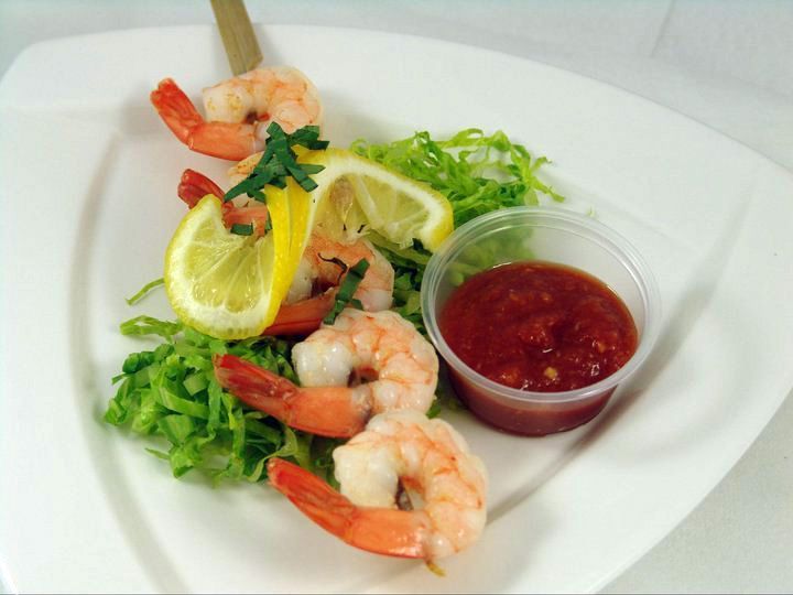 A white plate topped with shrimp and sauce.