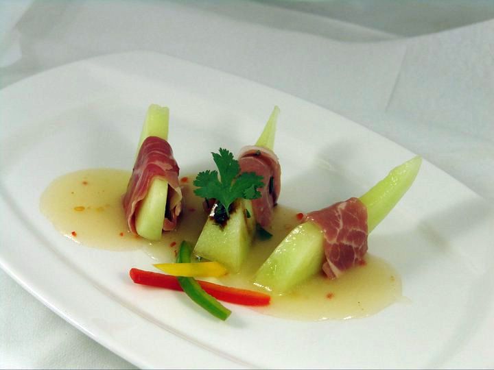 A white plate topped with meat and vegetables on a table.