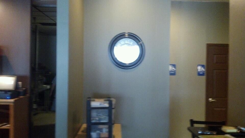 A room with a round mirror on the wall.