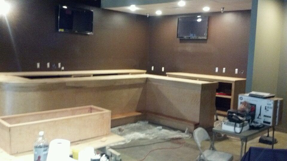 A room with a bar and a tv on the wall.