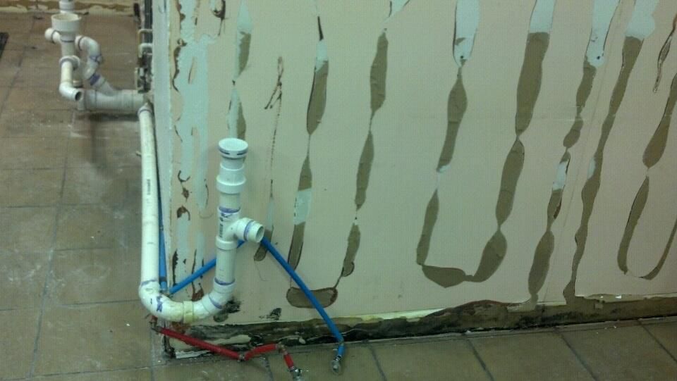 A wall with a lot of pipes coming out of it.