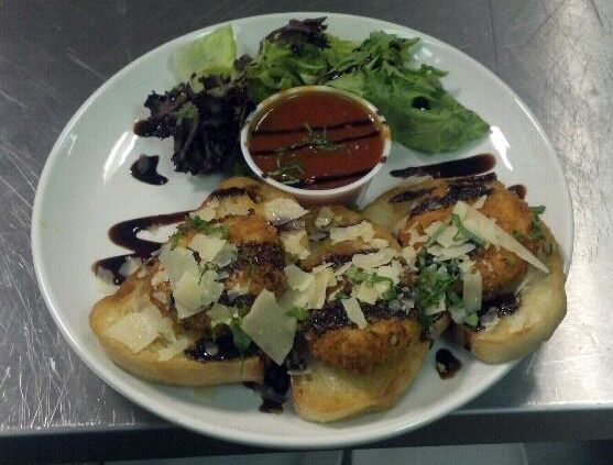 A plate of food with bread and a salad on a table.