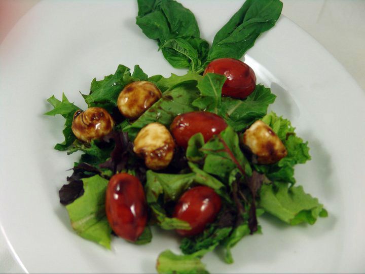 A salad with tomatoes and lettuce on a white plate.
