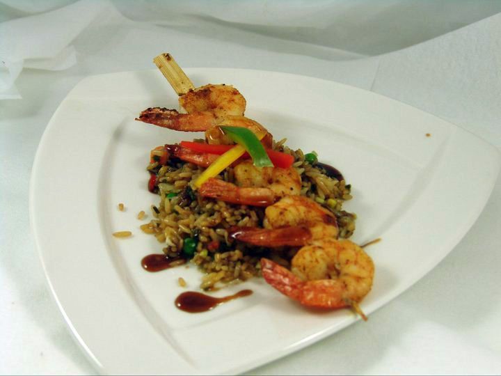 A white plate topped with shrimp and rice.