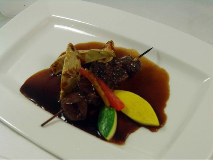 A white plate topped with meat and vegetables.