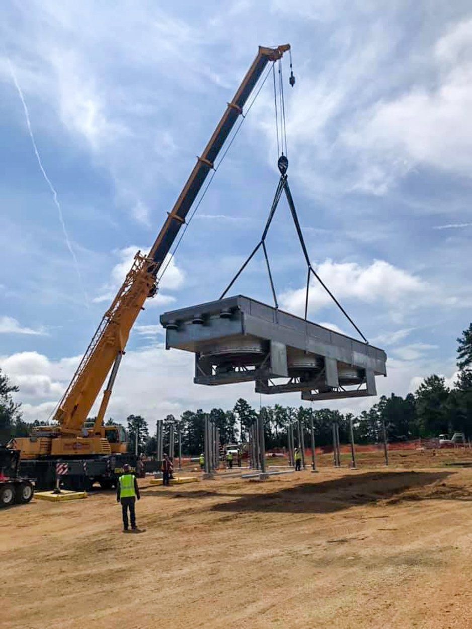 A crane is lifting a large piece of concrete into the air.